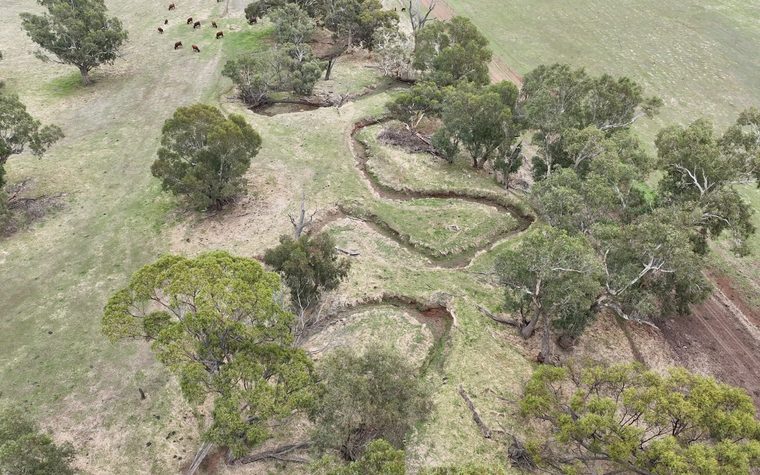 Aerial of a restored waterway winding through farmland
